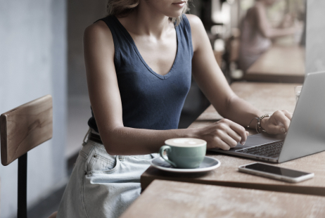 Attractive blond girl freelancer working laptop taking notes notebook sit alone cafe near window drink coffee professional writer make post online blog prepare files business meeting after lunch
